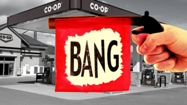 A toy gun in from of a backdrop of a co-op gas station