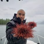 Douglas Neasloss holding two sea urchins.