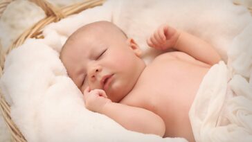 baby sleeping on white cotton