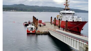 A red Canadian Coast Guard vessel reloading at a dock